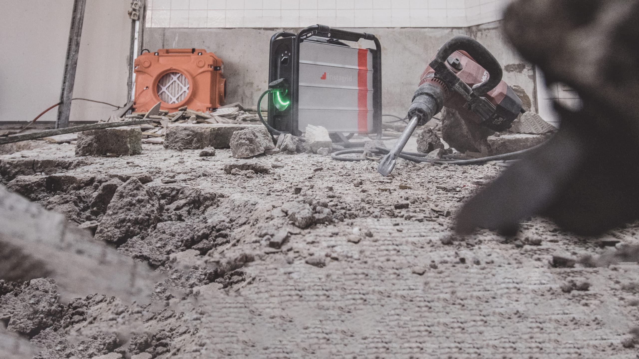 Jackhammer and broken concrete with background of instagrid ONE Max