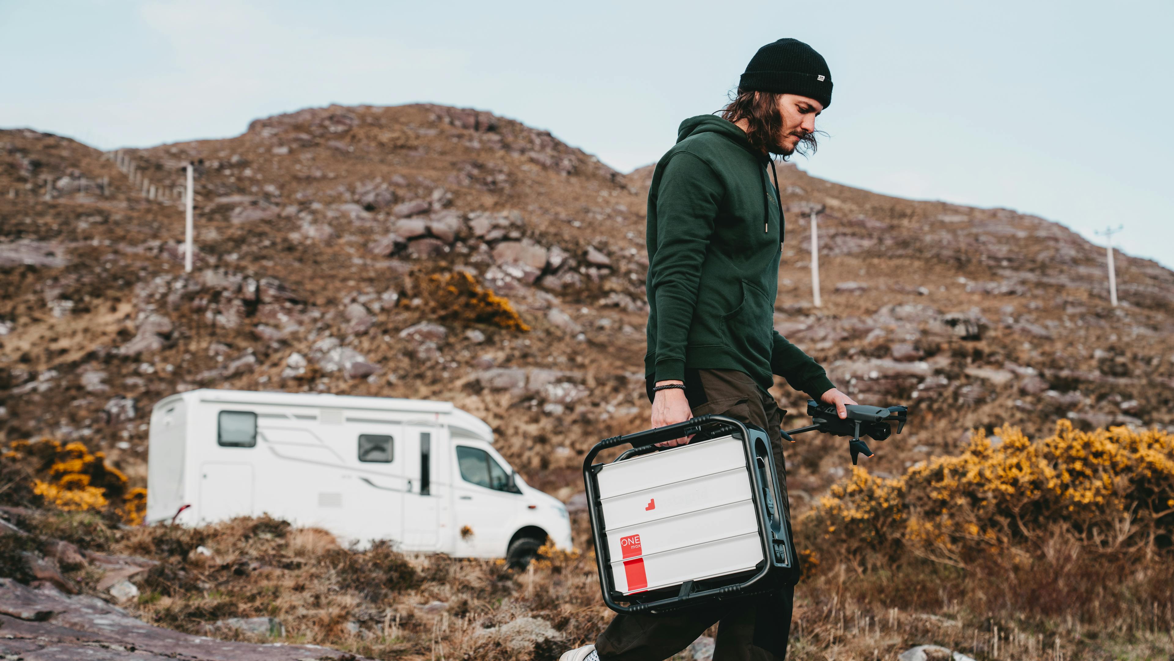 instagrid ONE max being carried by Ron from Convary content creation agency along with a drone in the other hand in rural, off-grid area of Scotland